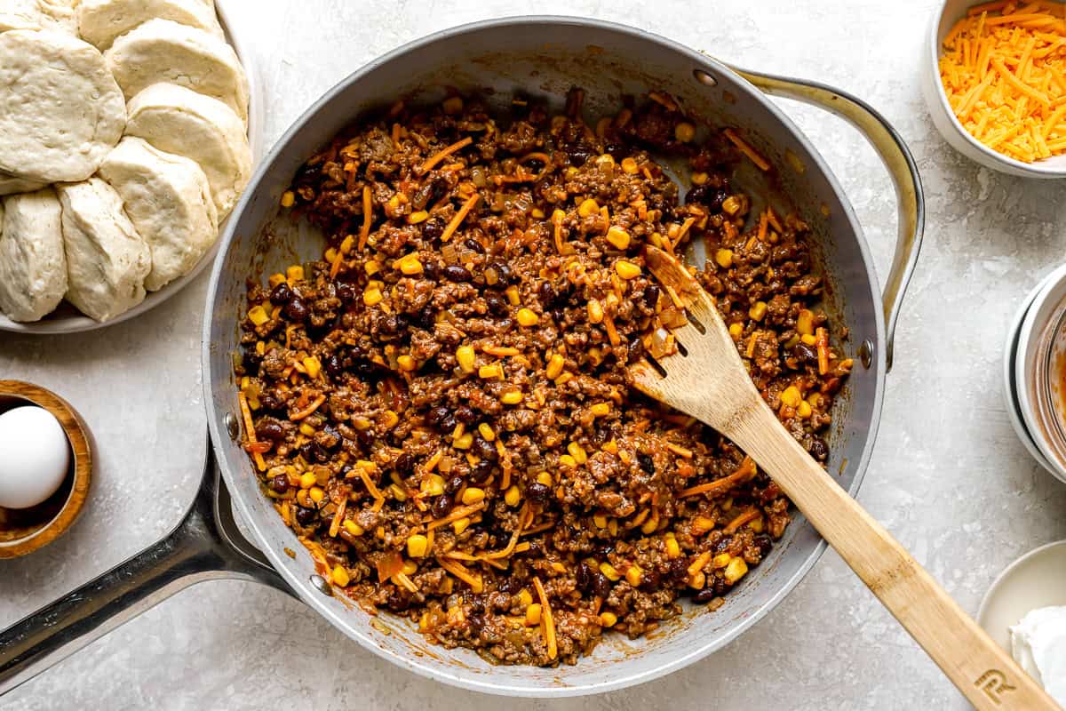 Ground beef mixed with black beans, corn, and shredded cheddar in a skillet for the hot pocket filling.