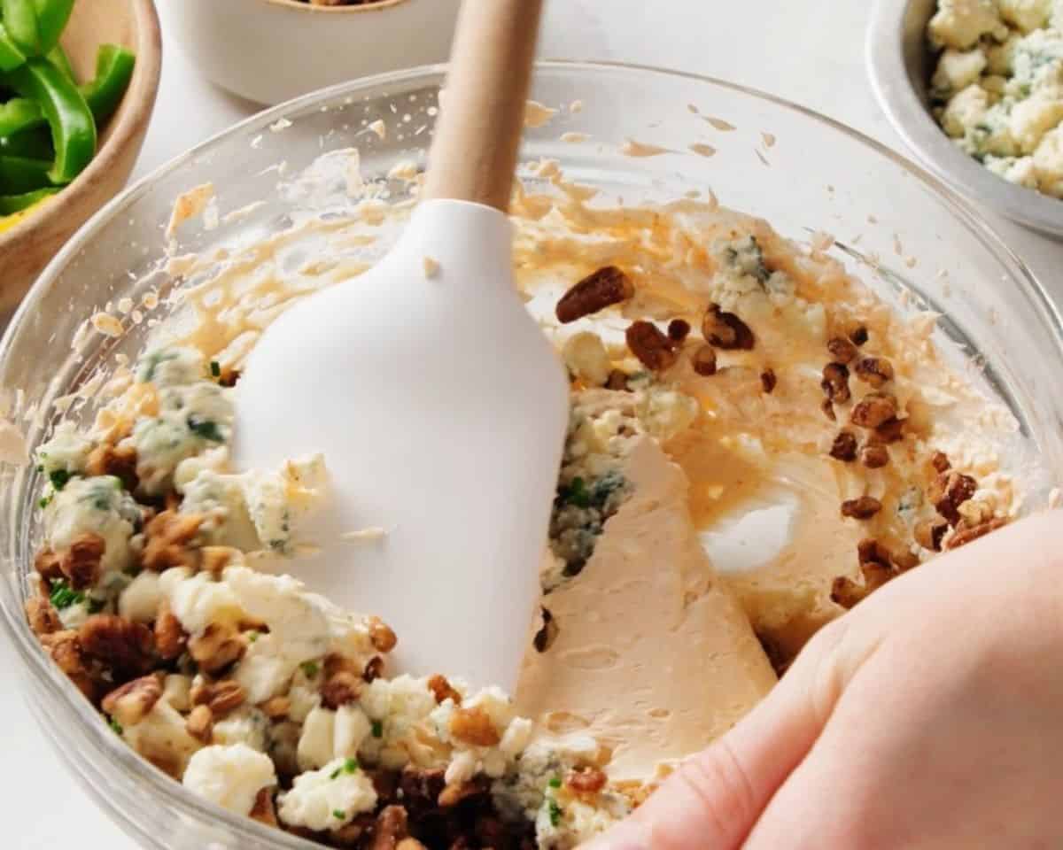 Adding blue cheese, chives, and pecans to the cheese mixture.