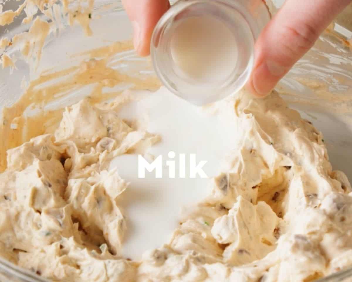 Adding milk to the cheese mixture.