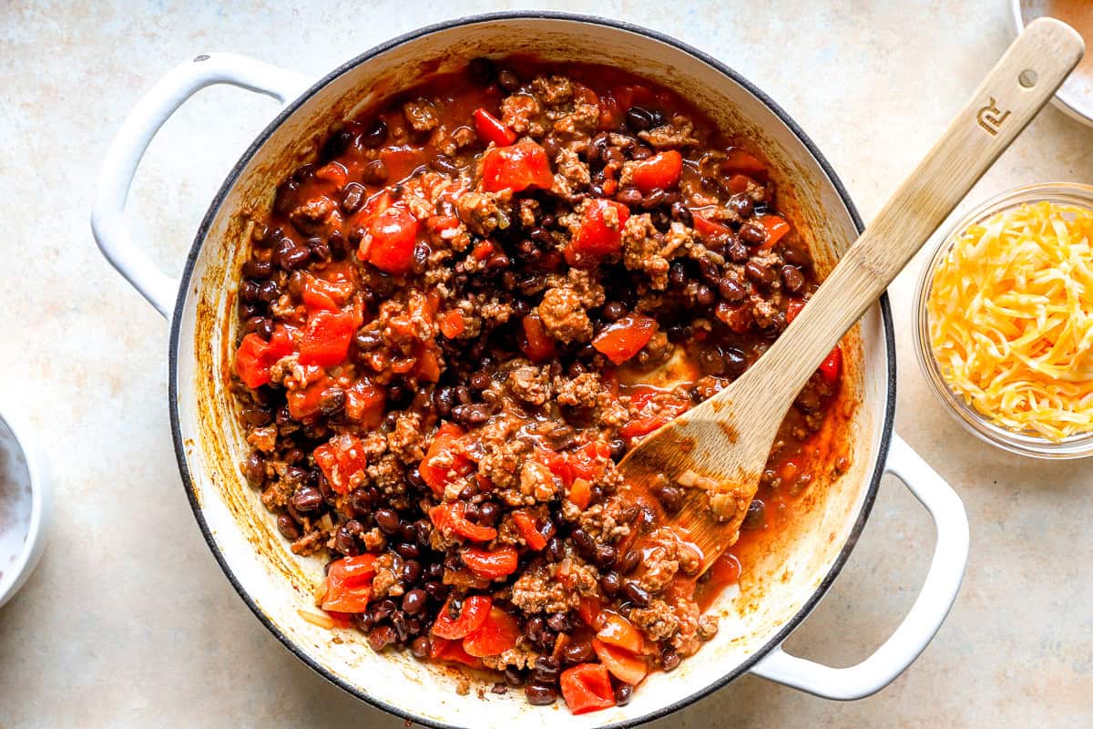 Ground beef simmered with black beans and diced tomatoes in a skillet, ready for the gnocchi.